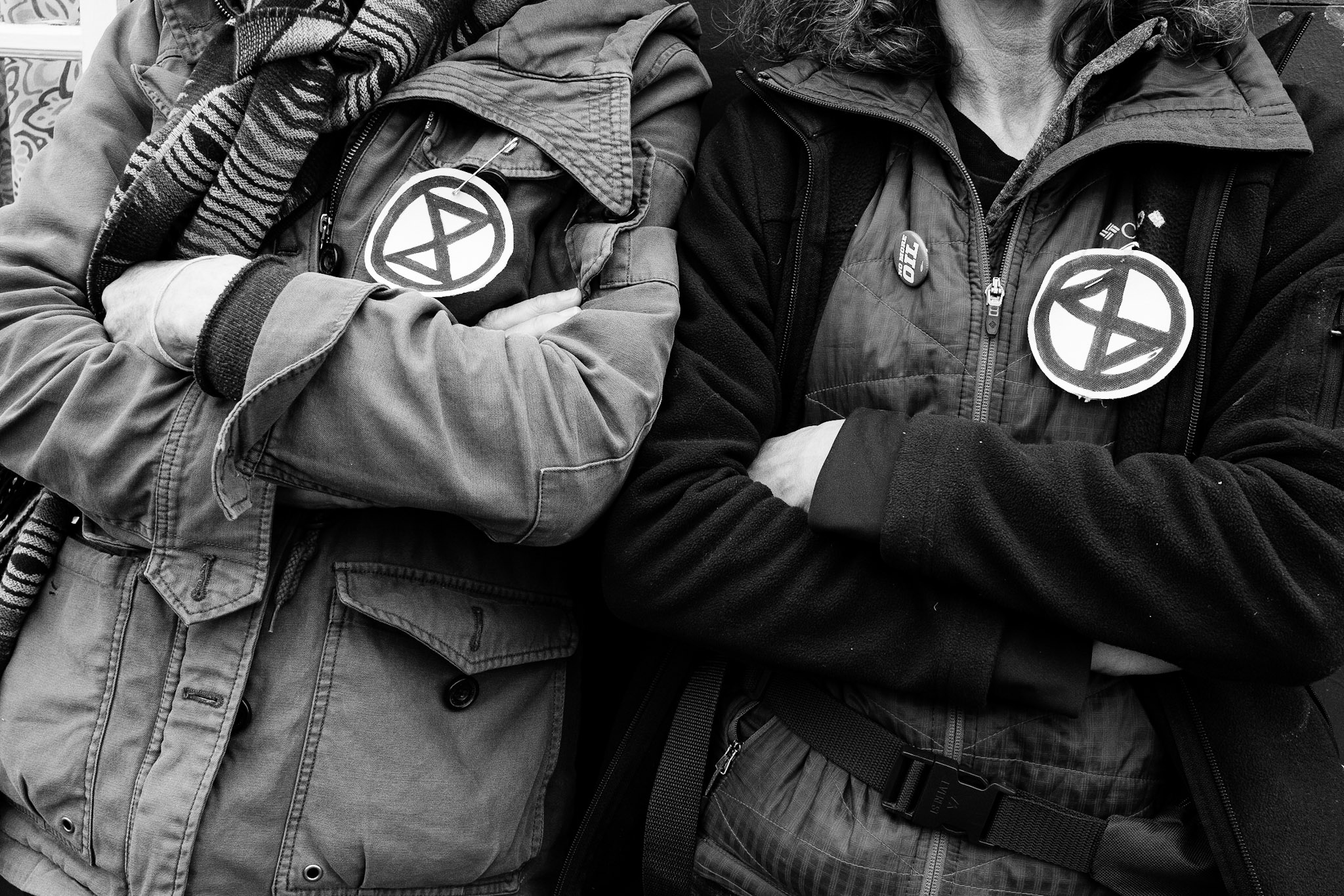B&W photo of two people where jackets with XR patches pinned to them.